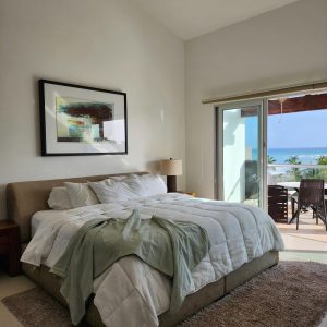 Chambre confortable avec terrasse vue sur l’océan, décoration moderne et lumière naturelle.