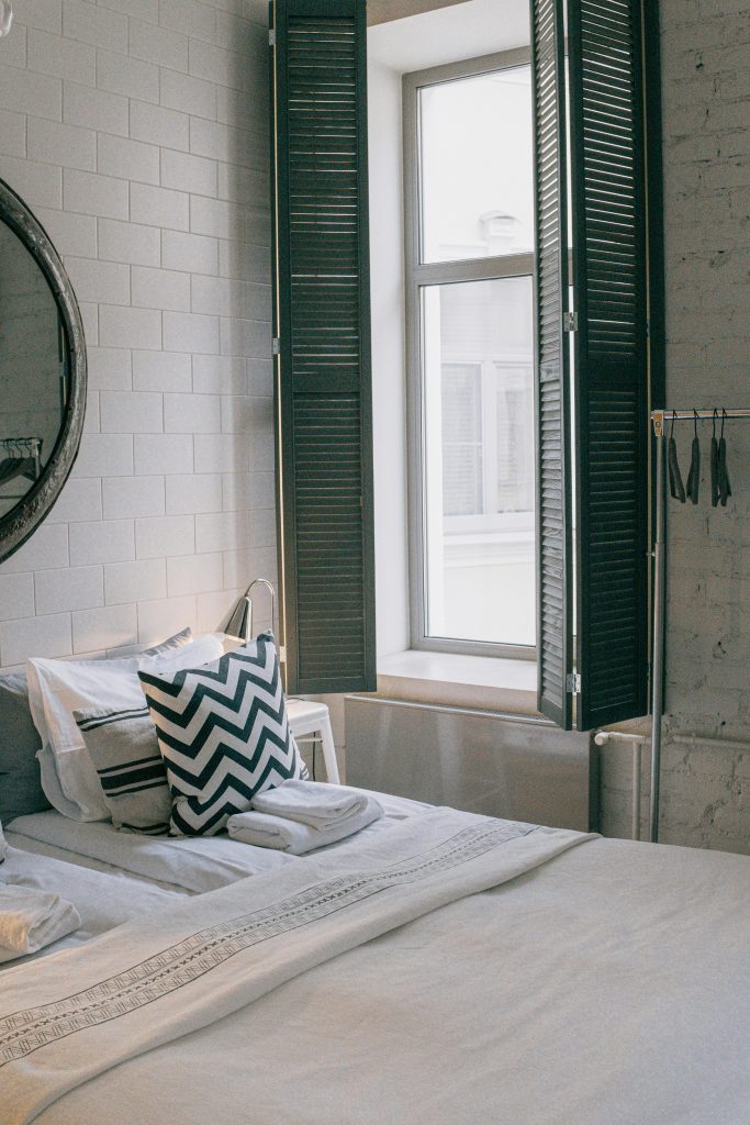 Une chambre confortable et stylée avec une décoration moderne et une fenêtre ensoleillée dotée de volets battants.
